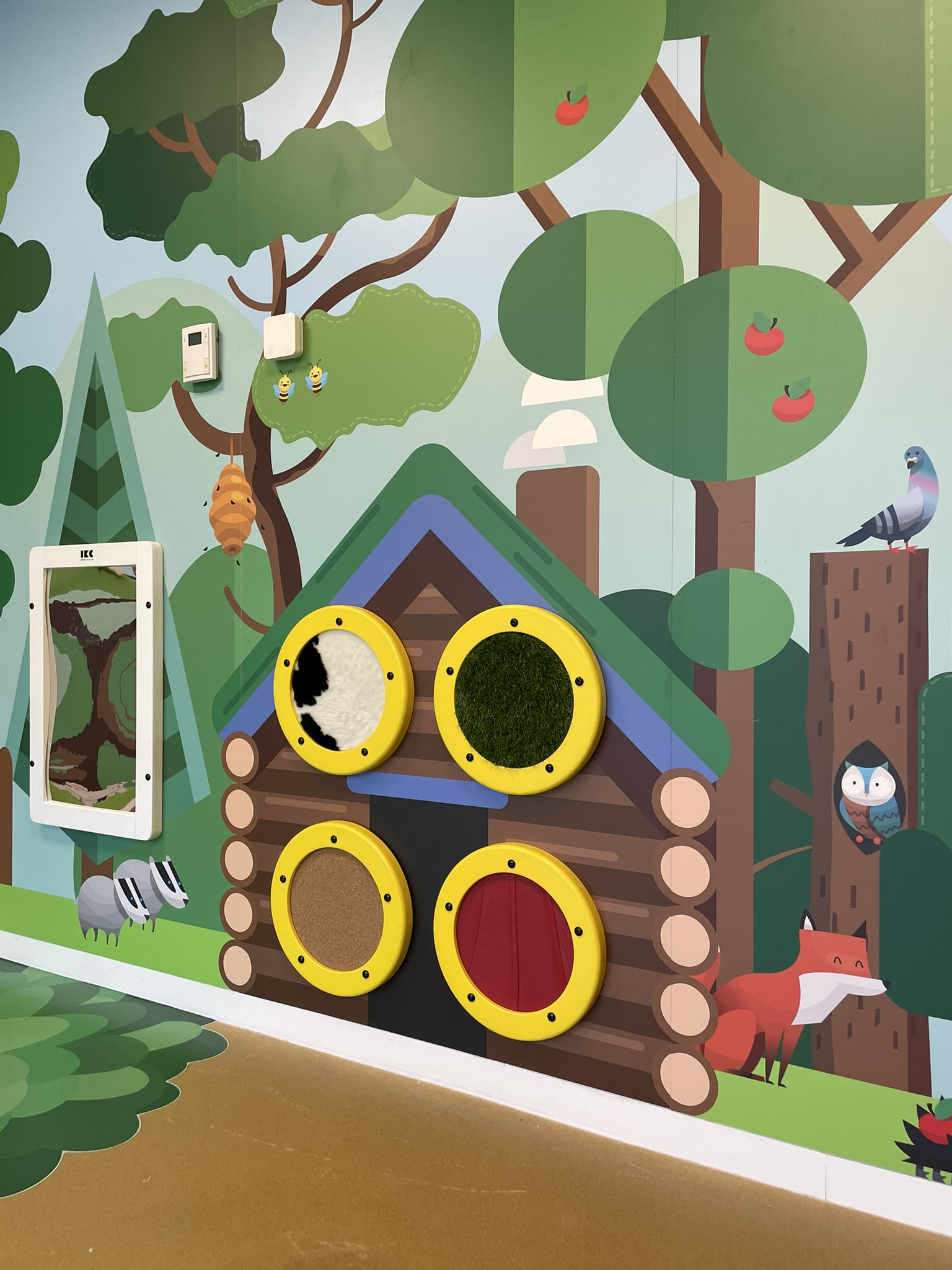 Tactile forest-themed play wall for children with interactive textures and animal illustrations by IKC