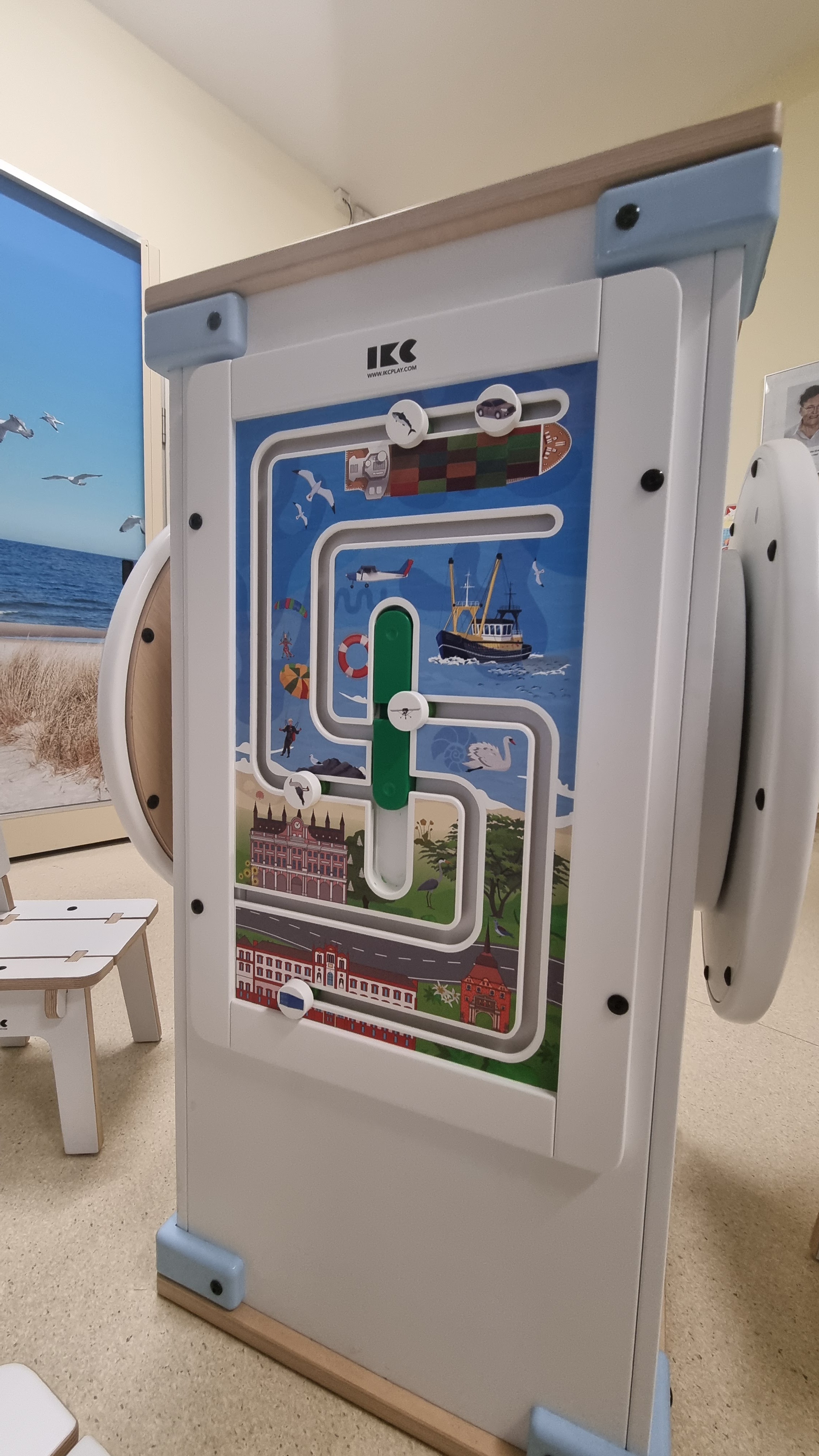 Interactieve wandtafel van IKC met kleurrijk doolhofspel en speelse illustraties in de wachtruimte van Universitätsmedizin Rostock.