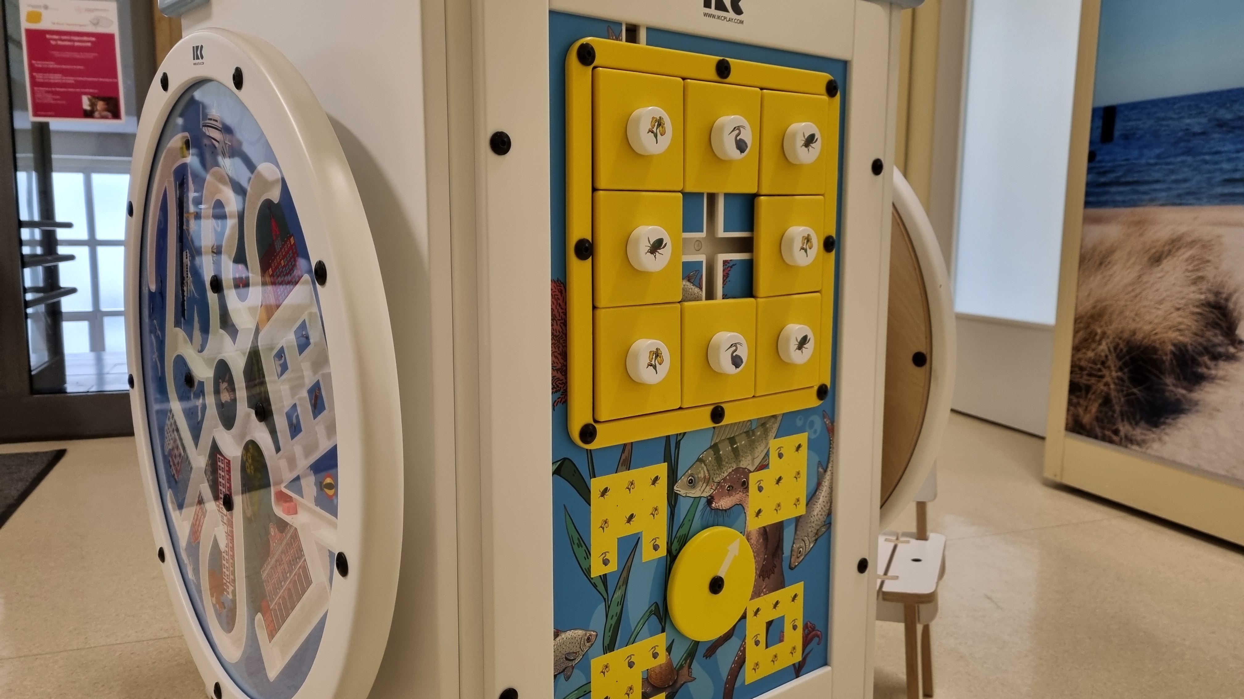 IKC speeltafel met interactief blokkenwandspel en rond draaispel in de wachtruimte van Universitätsmedizin Rostock.