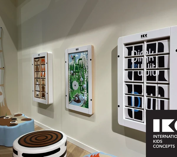 Wall-mounted play panels in a modern children's corner by IKC, designed for public waiting areas