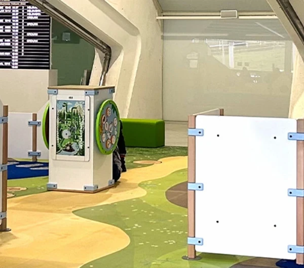 Overzicht van de maritiem gethematiseerde kinderspeelhoek op Bilbao Airport, met klimelementen, interactieve spellen en comfortabele zitplekken voor ouders.