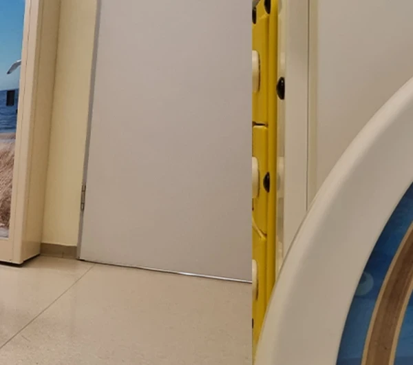 Interactieve IKC speeltafel en kinderstoelen in de wachtruimte van Universitätsmedizin Rostock, met speelse wanddecoratie op de achtergrond.