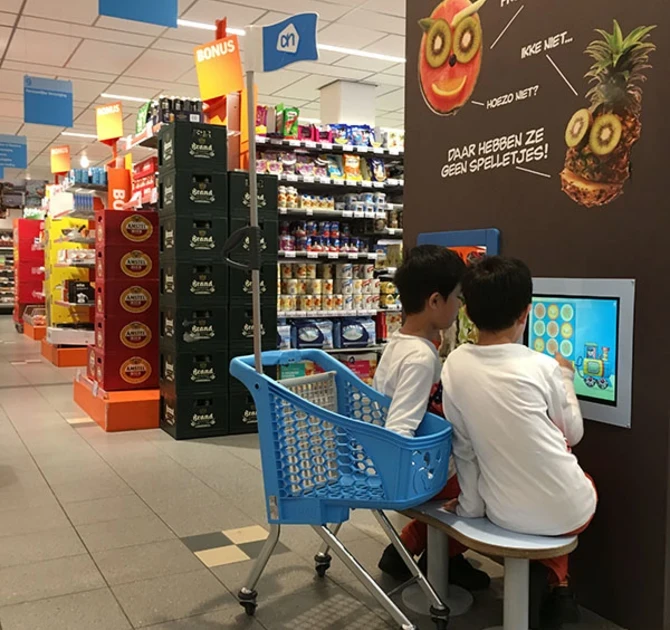 This picture shows two boys playing at the Albert Heijn kids corner supermarket