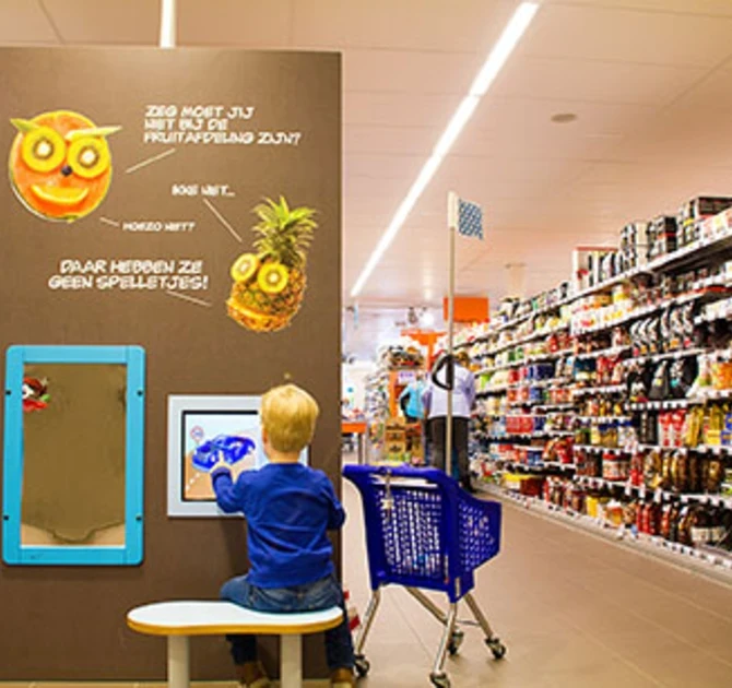 This picture shows a boy playing at the Albert Heijn kids corner supermarket