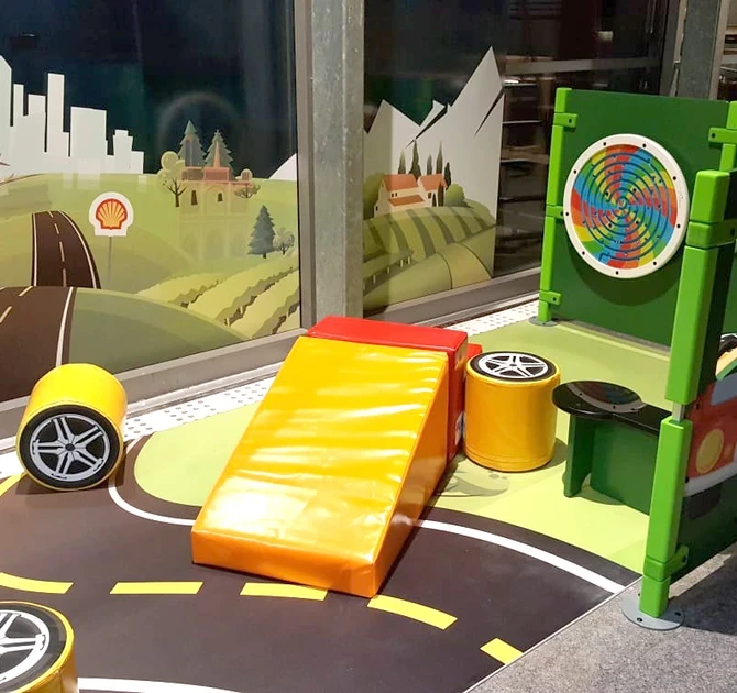 Kinderspeelhoek bij tankstation Shell in Frankrijk met verschillende speelmodules en wandspellen