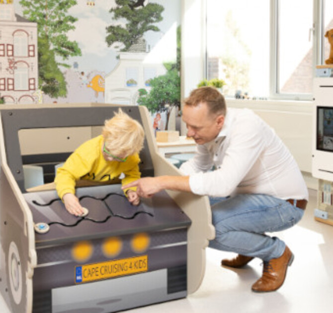 kind in speelauto van vernieuwde kindvriendelijke wachtkamer GHZ