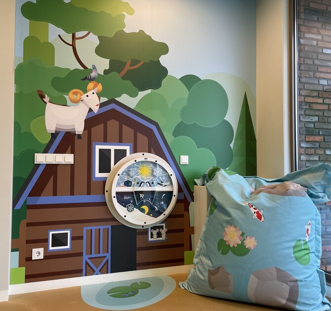 Children’s indoor farm-themed play corner with interactive wall panel, nature illustrations and soft seating